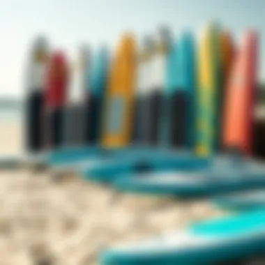 A variety of touring inflatable stand-up paddleboards displayed on a sandy beach