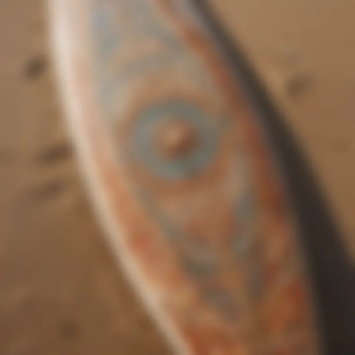 A close-up of a surfboard with intricate designs on the beach