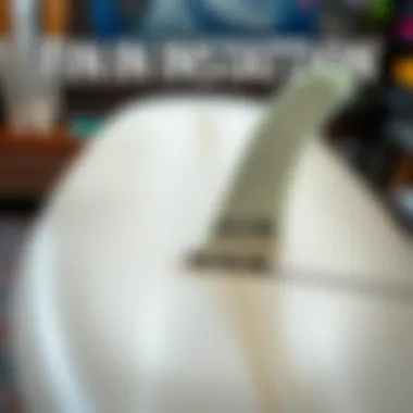 Close-up of FCS II fin installation process on a longboard