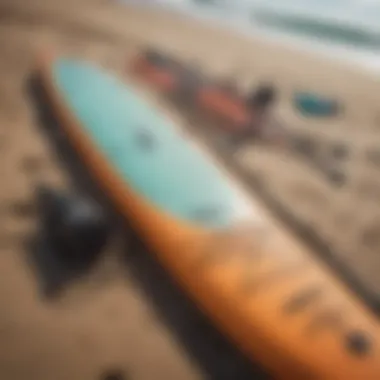 A close-up view of paddleboarding gear laid out on the beach